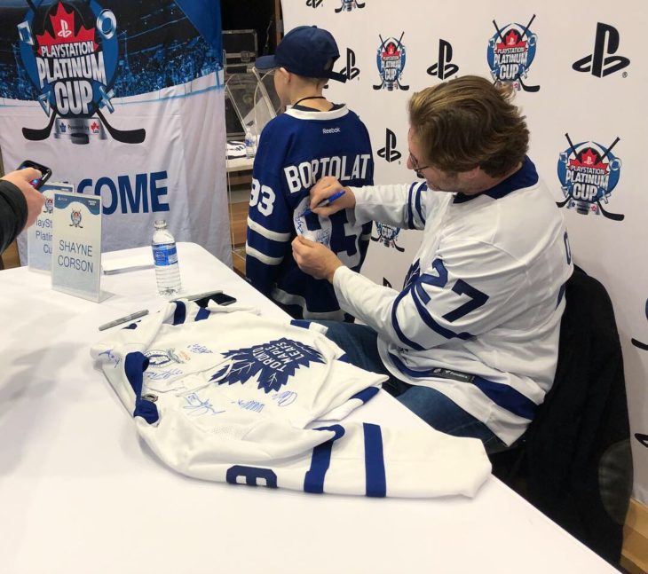 Former Toronto Maple Leaf Shayne Corson signs autographs for players. 